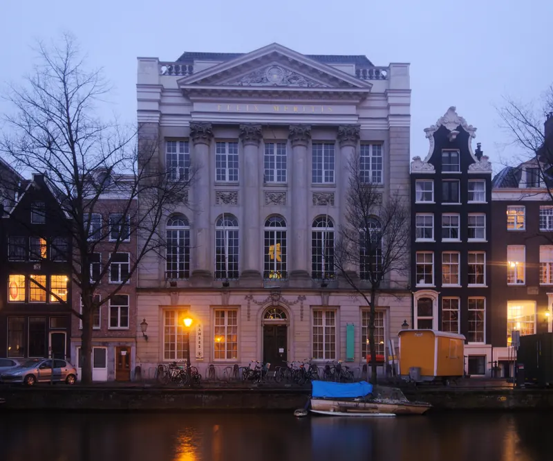 The columned facade of Felix Meritis on the Keizersgracht canal at dusk