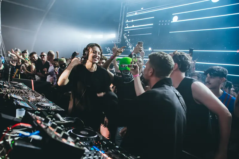 Sara Landry and Shlømo at the decks, with a crowd dancing behind them
