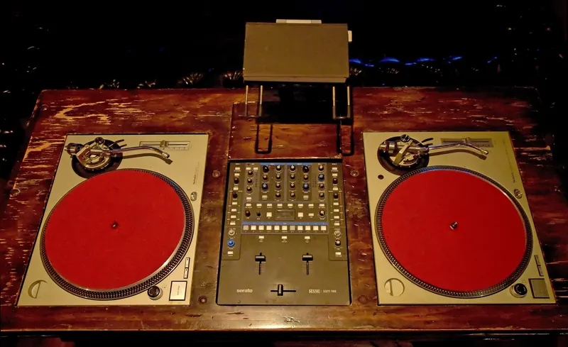 Two Technics SL-1200 MkII turntables and a Serato Rane Sixty-Two mixer set into a wooden DJ table